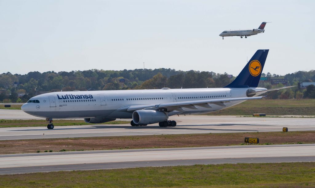 Airbus A330-300 (D-AIKF) - Lufthansa on departure runway 9L at KATL airport, with DL flight landing 9R.  Viewpoint- South Garage. 