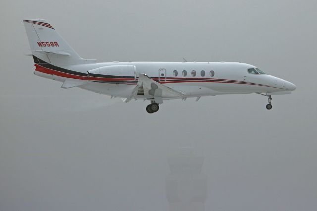 Cessna Citation Latitude (N558R) - N558R, a Citation Latitude on short-final for 24R on a foggy Friday morning (30 Nov 2018). You can just about see the top of the old tower through the fog.