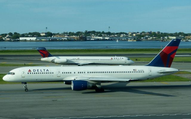 Boeing 757-200 (N645DL) - Delta 757-232 N645DL heads for the departure runway at KLGA while Company MD-88 N925DL taxis to the gate.