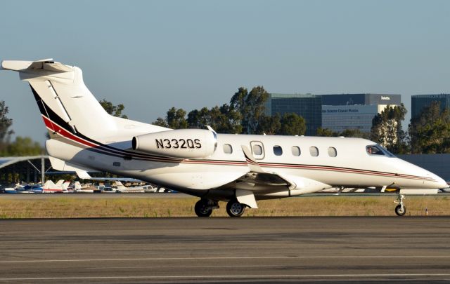 Embraer Phenom 300 (N332QS) - Net Jets N332QS taxing past my spotting location in the parking lot of Signature Flight Support. Photo  was taken just after 7am earlier in July.