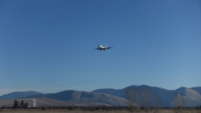 Embraer 170/175 (N204NN) - An early afternoon arrival into Missoula on a clear day. Taken November 25, 2023, just after noon. From an unnamed road on the south end of the field.