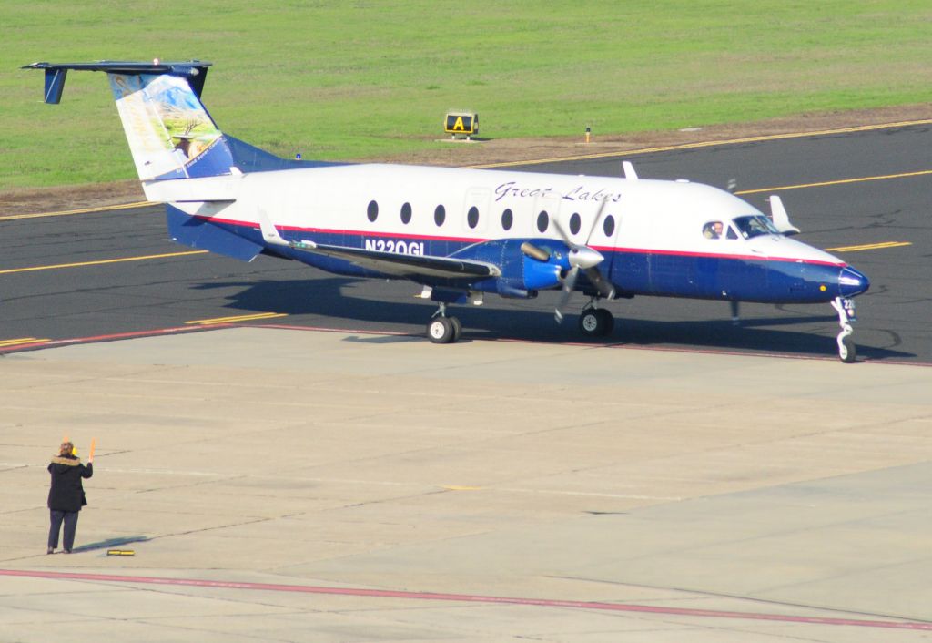 Beechcraft 1900 (N220GL) - Great Lakes flight 5194 arrives at Merced Regional Airport (KMCE) Katherine marshalls the airliner into the terminal parking.