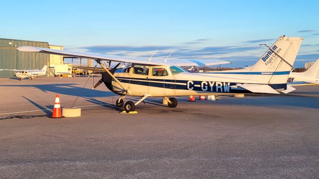 Cessna Skyhawk (C-GYRW) - Cessna 172 Skyhawk II (C-GYRW) parked on the ramp at Oshawa Executive Airport (CYOO) during golden hour. Operated by Durham Flight Centre, this aircraft is used primarily for flight training. Seen here secured with tie-downs and wheel chocks, with another training aircraft in the background.