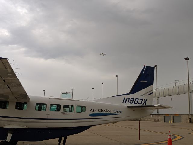 Cessna Caravan (N1983X) - N1983X loading at the gate with N732MD landing on RWY 29 at STL in the same frame! Taken on 07/03/2019.