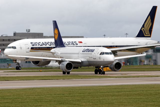 Airbus A319 (D-AILI) - DLH941 to Frankfurt dwarfed by the SIA B77W behind.