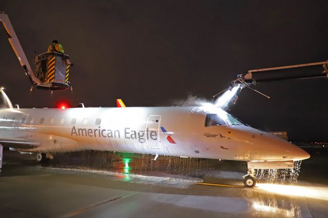 Embraer ERJ-145 (N682AE) - A close up of an American Eagle/Piedmont EMB145, N682AE, getting deiced as Lake Erie lake-effect snow settled in this morning, 1 Apr 2021. Once deiced, I had to inspect the radome and wing surfaces, aka “tactile inspection”, for residual contamination. This is what I do for part-time seasonal work if I’m not in the bucket or cab.