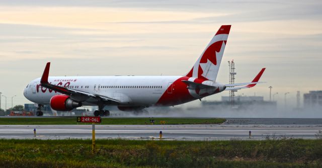 BOEING 767-300 (C-GHLV) - An Air Canada Rouge 767-300ER rolls down a very wet 06L, bound for somewhere much sunnier and warmer.