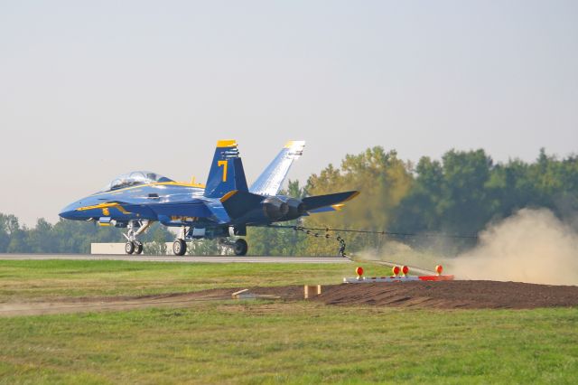 McDonnell Douglas FA-18 Hornet (16-3468) - US Navy Blue Angel #7, 163468, cn 0691, taking the barrier as grass and debris is kicked up from the tape rapidly dragging across the ground surface. This was the first time an aircraft arresting system was utilized at KYNG (1 Sep 2010).