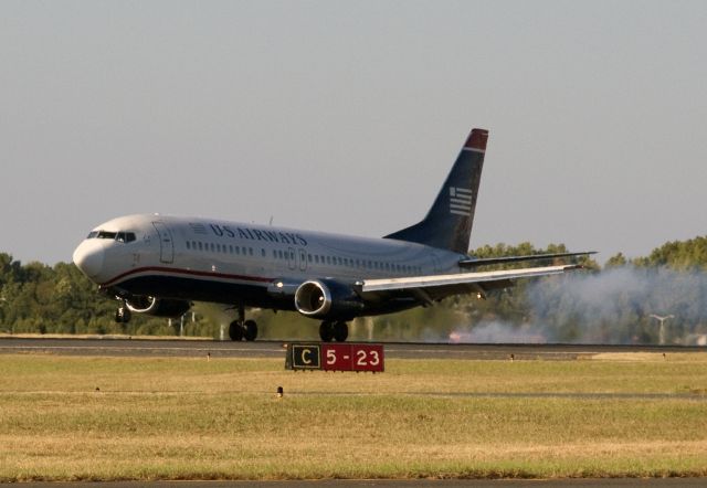 BOEING 737-400 (N404US) - The continuing saga of "404." After heading off into the sunset on September 23 (click "3 photos" above), it enjoyed the RON nightlife of Houston. "RON" in aviation parlance means "Remain Over Night." Not finding love, and looking in all the wrong places, our intrepid traveler came back to Charlotte, picked up a bunch of happy kids and apprehensive parents and headed for Orlando and Disney World! Then it was back to Charlotte for big gulp of jet fuel and gaggle of tired businessmen and off to the Big Apple and bright city lights for a restful evening at Newarks Liberty Airport. Wheww!