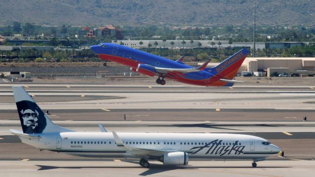 Boeing 737-900 (N457AS) - An Alaska 737-900 taxies to Terminal 2 as a Southwest 737 takes off.