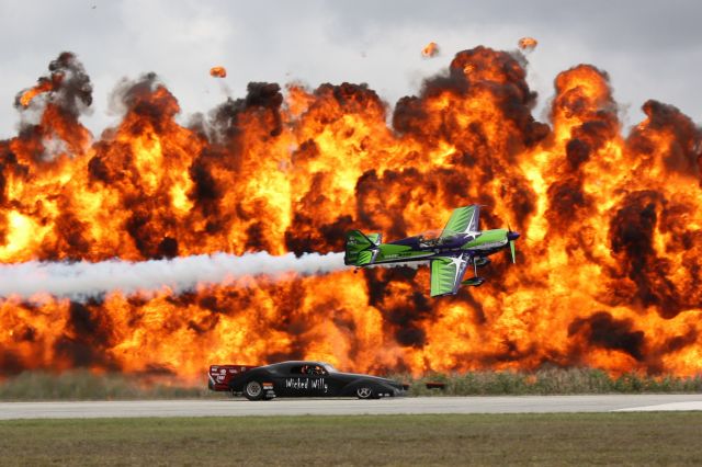 Experimental 100kts (N716GW) - Gary Wards MX-2 races the Wicked Willy Jet Funny Car in front of the Wall of Fire at the 2012 Florida International Airshow