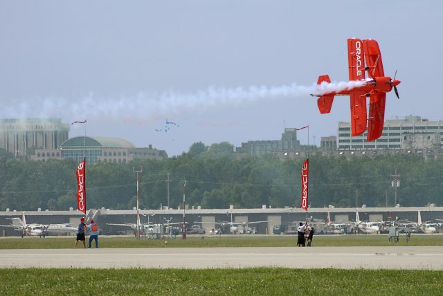 — — - Oracle plane cutting the ribbon between the two poles, with its wing.