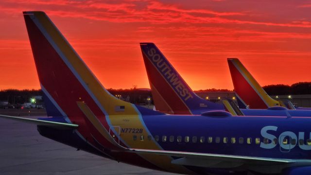 Boeing 737-700 (N7722B) - Row of 737s awaiting pushback against the sunrise in Windsor Locks. View from Terminal A on August 27, 2020.