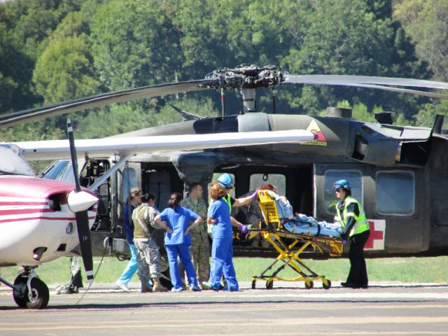 — — - Army chopper delivering patient to waiting ambulance.