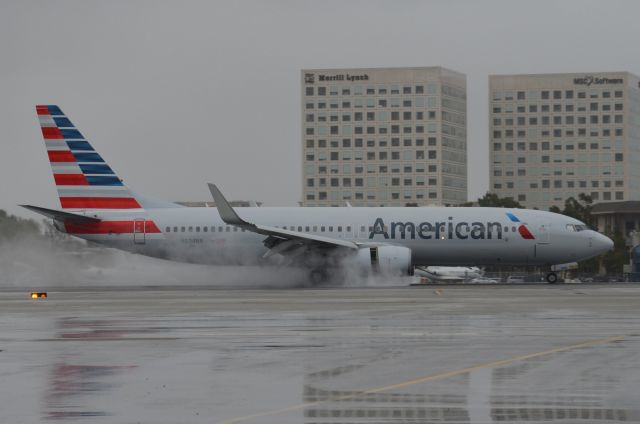 Boeing 737-800 (N804NN) - N804NN hitting the brakes after touching down on the 5,600 foot runway in rainy and wet conditions.