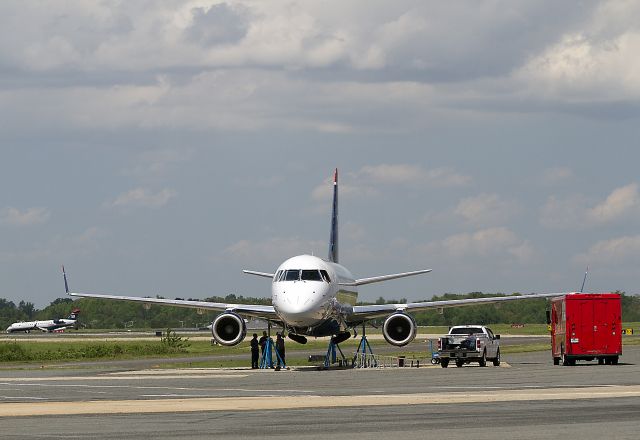 Embraer 170/175 (N128HQ) - Getting jacked up on Mothers Day. Aircraft Maintenance Technicians quickly and efficiently jacked up this Embraer 170 and accomplished a landing gear retract check. In this photo the the main landing gear are almost fully retracted, the nose gear doors are almost closed.