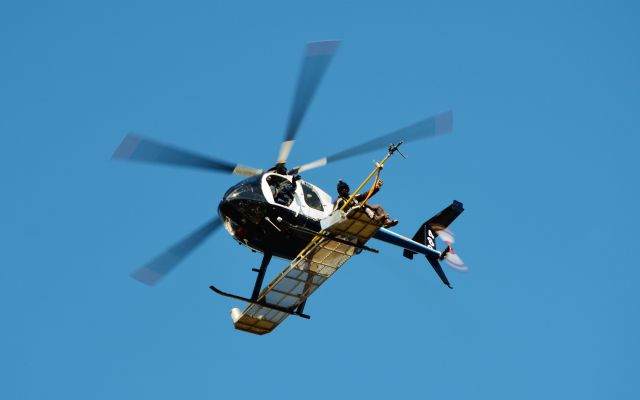 MD Helicopters MD 500 (VH-SUV) - Power line cleaning near George Town, NE Tasmania.  Just took off and waving to the kids on the ground near Batman Bridge.