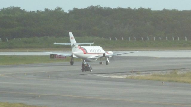 British Aerospace Jetstream Super 31 (HI840) - motorbike and side car following plane down runway at Cayo Coco Cuba 24/09/2010. A novel piece of air traffic control