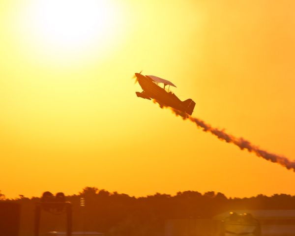 Experimental 100kts (N181DM) - Dan McClung of the Red Eagle flight team climbs into the sun during the performance at the twilight air show Saturday night at the Field of Flight.