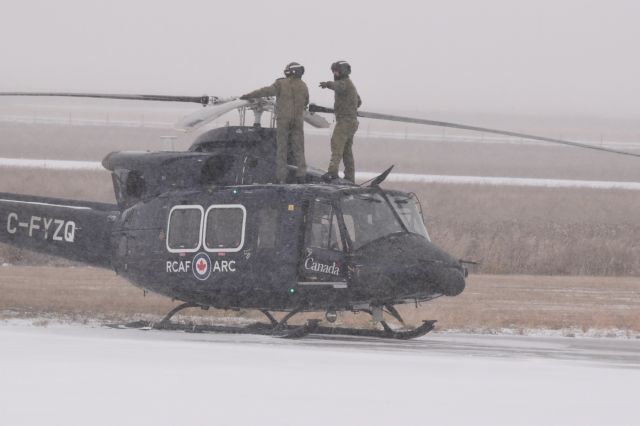 Bell 412 (C-FYZQ) - RCAF crew checking the rotors on this Bell 412 prior to a very snowy departure from Yorkton. It created the biggest snow wash ive ever had. Was totally cool (ah cold)!!