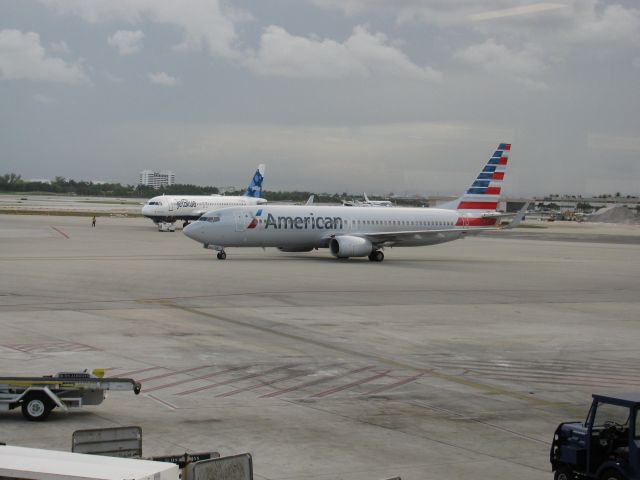 Boeing 737-800 (N805NN) - An American Airlines 737-800 taxiing past a jetBlue A320 in pushing back. KFLL Marriott visible in background.