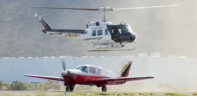 N911NV — - It may appear that "RAVEN One," the Washoe County Sheriff Departments Bell HH-1H Iroquois helicopter, is making a traffic stop on a Bellanca, but in reality the WCSDs R(egional) AV(iation) EN(forcement) helicopter is just kicking up a bit of dirt as it waits for the just-landed Bellanca to taxi to the Carson City Airport ramp.  Both aircraft were arriving to participate in the annual Carson City Airport Open House.