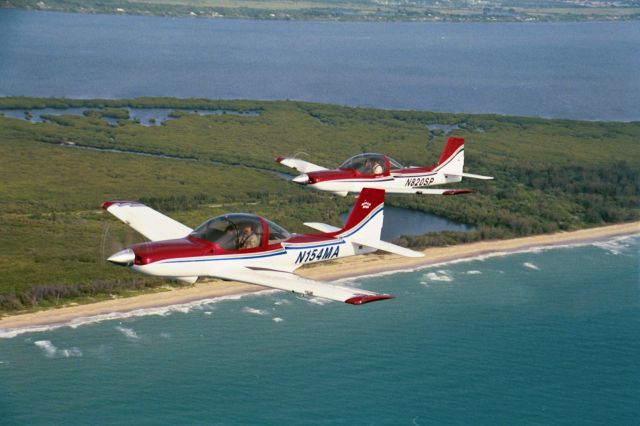 — — - Two MICCO SP26A Aerobatic aircraft in formation over the beach at Fort Pierce, FL (2001)