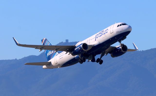 Airbus A320 (N809JB) - KSJC - "Blue by Popular Demand" climbing out of 30R at San Jose on a nice clear day headed to Long Beach,CA. Note the 1950s Era US Air Force Station "Mt Ununhum" coastal air defense base radar tower( minus the array) shown atop the mountain of the same name in the distance. I worked on that base property late 1970s for a different Company that had to let us in to check certain facilities each month. The view is awesome up there when clear, and recently this area of the old Radar base is now open to the public as a County park from 2017.