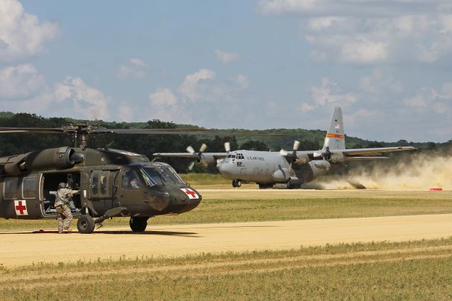 Lockheed C-130 Hercules (92-1452) - US Army National Guard UH-60A Black Hawk 82-23698 preparing to liftoff as a USAF Lockheed C-130, 92-1452, cn 382-5329, from the 169th Airlift Squadron (AS), 182d Airlift Wing (AW), Peoria, Illinois ANG kicks up the dust on takeoff from Fort McCoy/Young Tactical Landing Site-Air Assault Strip, Ft. McCoy, (WS20) USA – WI, during Warrior Exercise 86-13-01 (WAREX) on 17 Jul 2013. There were many simultaneous fixed-wing and rotary-wing operations throughout the exercise.