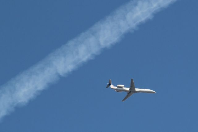 Embraer ERJ-135 (N16571) - ASQ6027 from KGRB, on approach to Runway 10 at KORD.  The contrail is from AFR438, a B744 flying LFPG-MMMX.  Viewed from Elgin, IL.