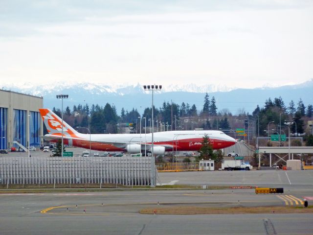 N6067E — - ROLL OUT SERIES #7:  Boeing 747-8 Intercontinental RC001 Business Jet for undisclosed government  customer being pulled over Boeing Freeway (highway 526) cross-over bridge on 2-13-2011 roll-out day at Paine Field, Everett, Washington  ||||   Photo by Bruce McKinnon