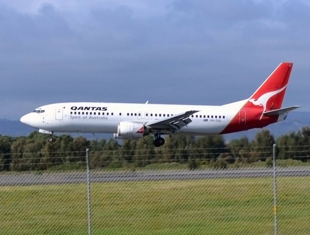BOEING 737-400 (VH-TJU) - A Qantas "old girl" seconds from touch down on runway 05.