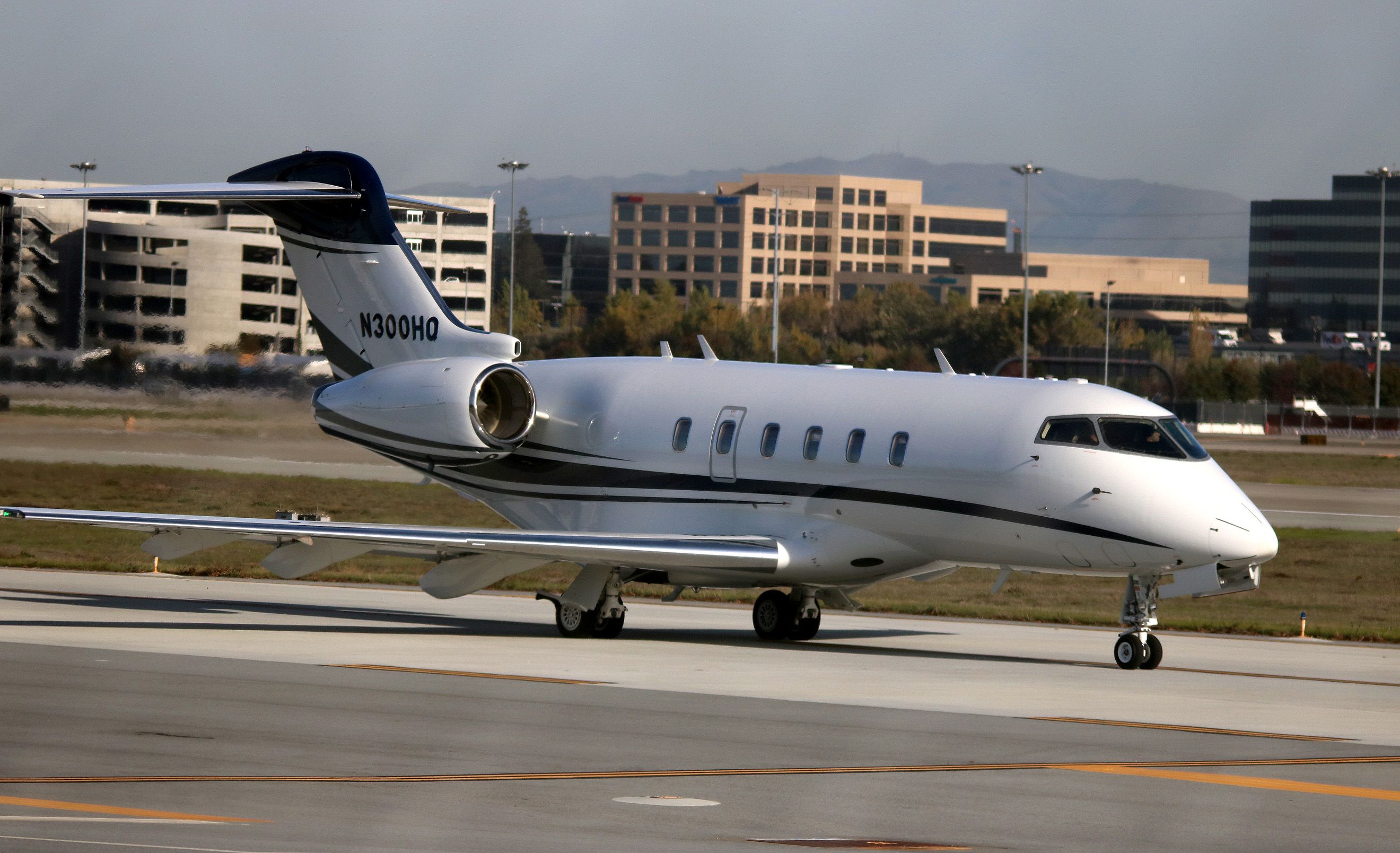 Bombardier Challenger 300 (N300HQ) - Taxiing out for departure, 30L.   Image captured looking through, new 11 ft security fence.