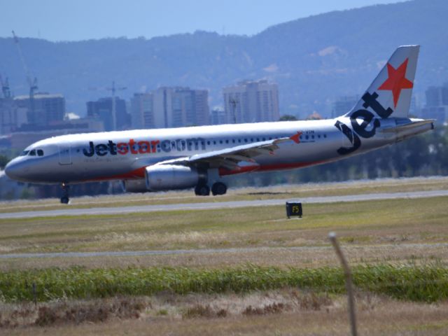 Airbus A320 (VH-VGN) - On taxi-way heading for Terminal 1, after landing on runway 23. City of Adelaide skyline appears in the background. Wednesday 4th January 2012.