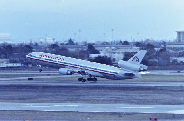 Boeing MD-11 (N17XX) - KSJC - early to mid 1990s American MD-11 departing late off Runway 12R for Tokyo-Narita..view from the parking structure. With Boeing 777s on the horizon, we had little time left with the MD-11s soon to be taken over by the 777-200s on this route.