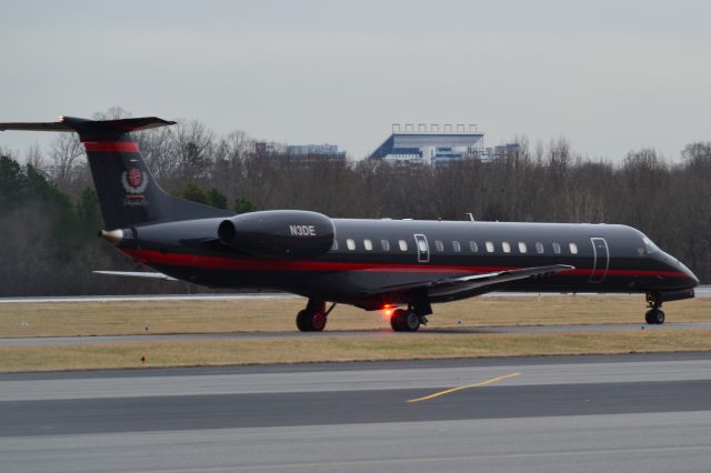 Embraer ERJ-145 (N3DE) - CHAMPION AIR LLC (UNCC basketball team headed to North Texas) at KJQF taxiing to runway 2 with Charlotte Motor Speedway in the background - 1/3/18 