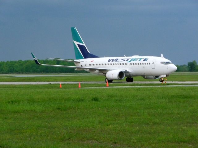 Boeing 737-700 (C-FWBW) - Taxing to CYXU/YXU terminal,Early evening after a thunderstorm had just passed by.