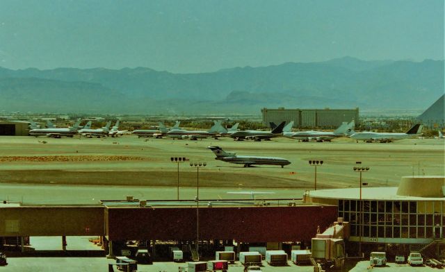 — — - KLAS - from atop the parking structure looking west, July 1995 - about 115 degrees shows the Las Vegas aircraft storage lot - the Mandalay Bay Resort covers most of this area left of the Luxor where the other building is, that was torn down many moon ago. I wish I had gotten the 747SP registrations, there was a road I could drive by on in that area.