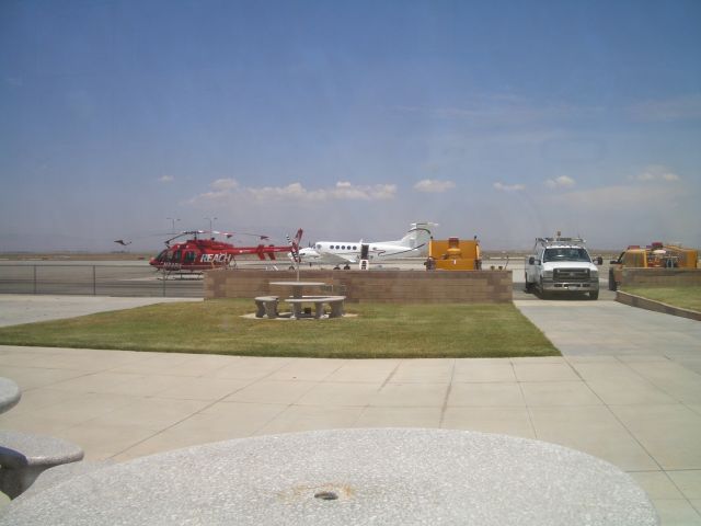 Bell 407 (N48RX) - The AV Hospital helicopter parked beside a King Air at Kwjf  . Picture taken from inside of Foxys Landing Restaurant inside the terminal.