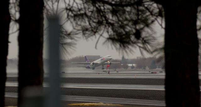 Boeing 757-200 (N937FD) - It was a gray and dismal morning as I caught this snap of FDXs "Aley" (N937FD) beginning its early morning climb away from RTIAs runway 34L.  I kicked around whether or not to share this one, but I decided I will.  I like the framing.  It is a different view; out of the ordinary.  Yes, I know; some will like it; some wont.  I like unusual shots like this and when Lady Luck and the Spotters Gods combine to offer up a unique capture like this, I take it whether the weather is perfect or not.  It was a dark, wet, and dreary morning with heavy clouds, but the shot came out fine.