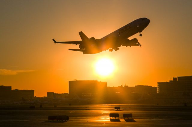 Boeing MD-11 (N528FE) - Blinded by the sun, this FedEx MD-11 is taking off from runway 25R in the early morning at LAX. See the companion photo of its climb out for a normal look. 17 January 2015 07:10 am