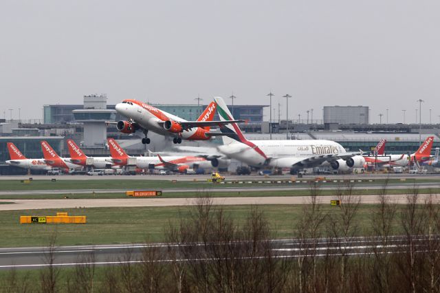 Airbus A319 (G-EZFI) - EZY1847 off to Pisa against a background of sister ships along T1 with the Emirates A380 towering over them.
