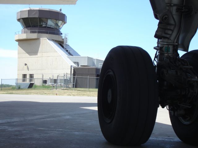 Airbus A319 (C-FYJG) - Close up of main gear on an Air Canada A319 at Fort McMurray, Alberta, Canada with Flight Service Station in background.