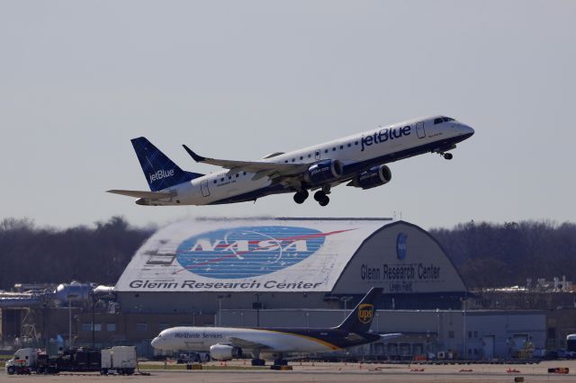 Embraer ERJ-190 (N258JB) - JBU440 passing by the iconic NASA hangar and UPS ramp while departing RWY 6R, bound for Boston Logan Intl (KBOS) Sunday 10 Apr 2022. 
