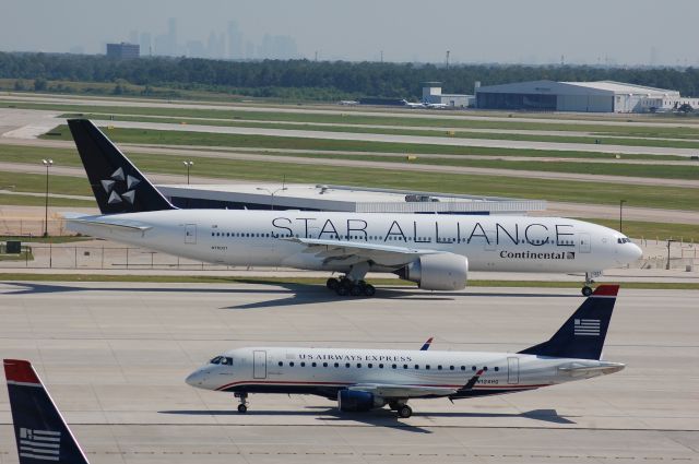 Boeing 777-200 (N76021) - COA 777-200 taxiing on RB while a US Airways ERJ-175 taxis in on RC.