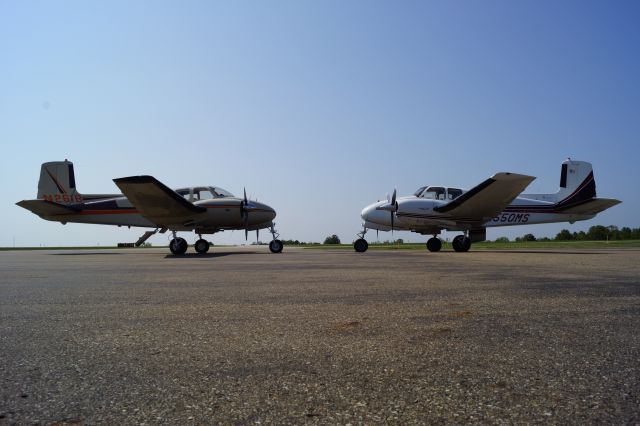 Beechcraft Twin Bonanza (N261B) - Two Beechcraft Model 50 Twin Bonanzas on the ramp of Knox County Airport in Ohio.  Pretty rare to see two of these classics together nowadays.