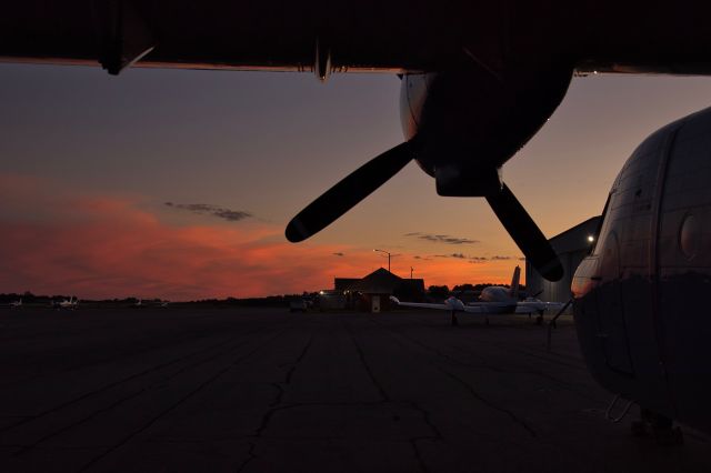 NURTANIO Aviocar — - Sunset from under the wing of a Casa C-212 towards the FBO building.