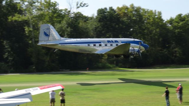 Douglas DC-3 — - Low Pass over the golf-course-like grass runway at Triple Tree Aerodrome September, 2013.