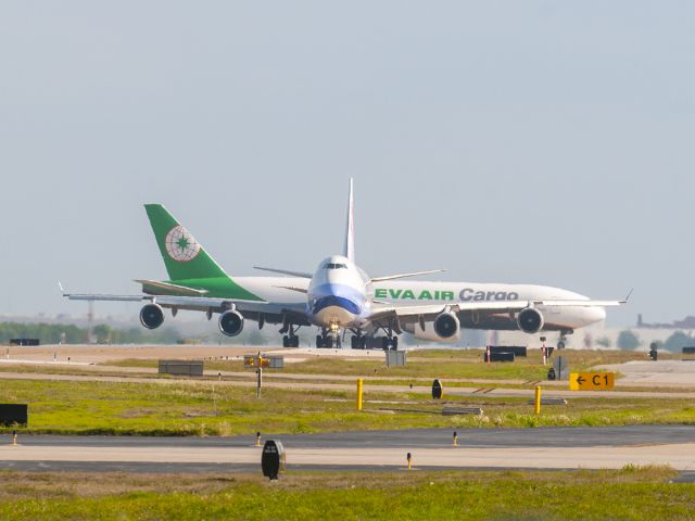 Boeing 747-400 (B-18718) - 5/7/2020 Dynasty 744 leaving the W. Cargo Ramp while EVA 772 B-16781 heads for the Cargo Ramp.