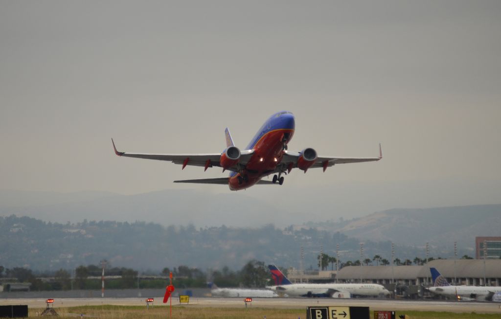 Boeing 737-700 (N228WN) - This photo of N228WN was snapped from the departure end of runway 20R. It was the exact same spot that the captured the Alaska 737-800 from, which I uploaded last week, but the Southwest got up a lot faster and I wasnt able to capture a closer picture than this as it climbed too high too fast.